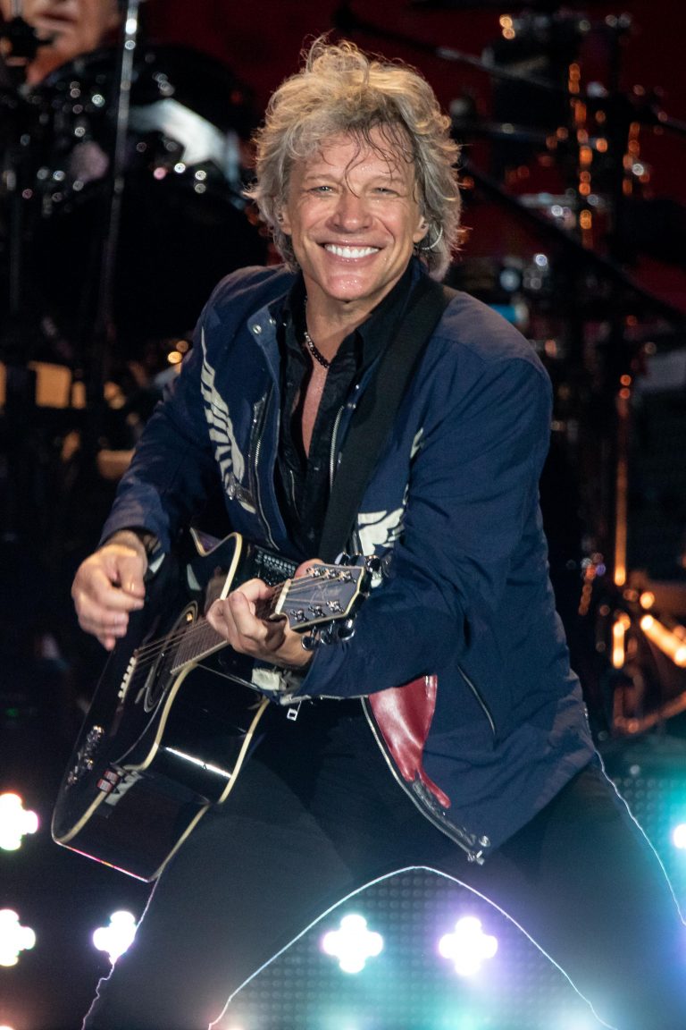 Jon Bon Jovi playing guitar under stage light