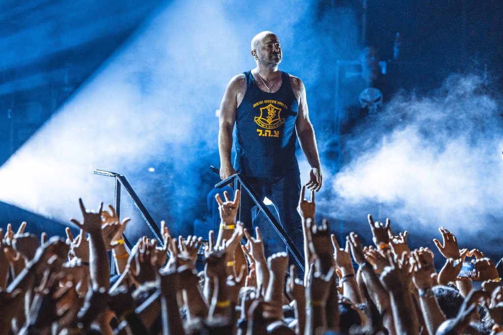 David Draiman of Disturbed on stage above a packed arena crowd
