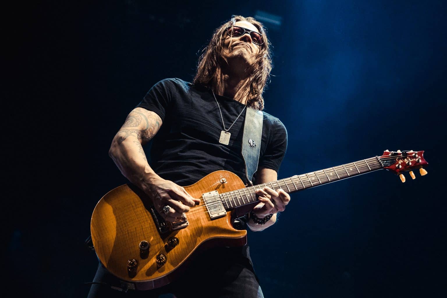 Myles Kennedy playing a gold-top guitar on a festival stage