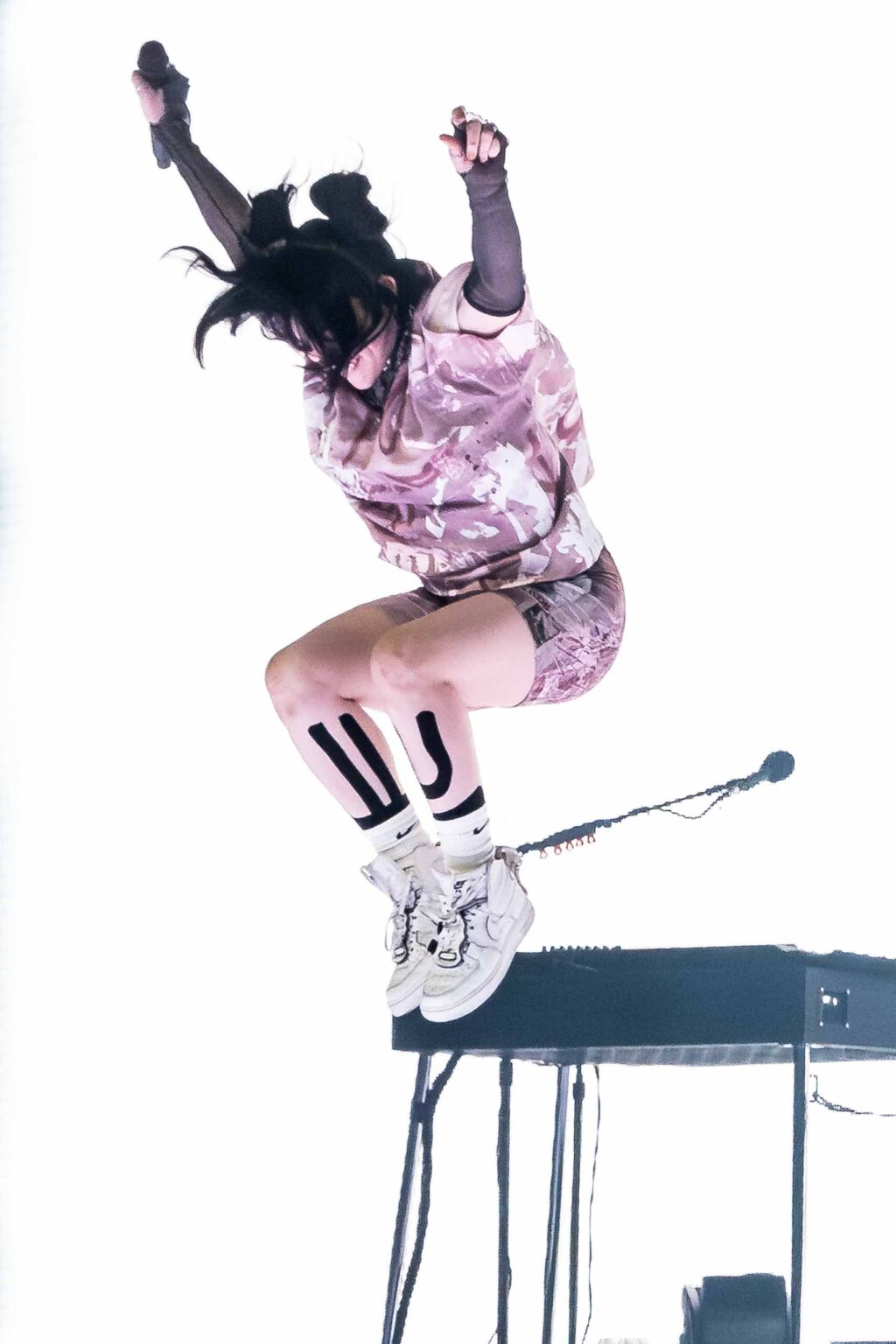 Billie Eilish leaping mid-air on stage