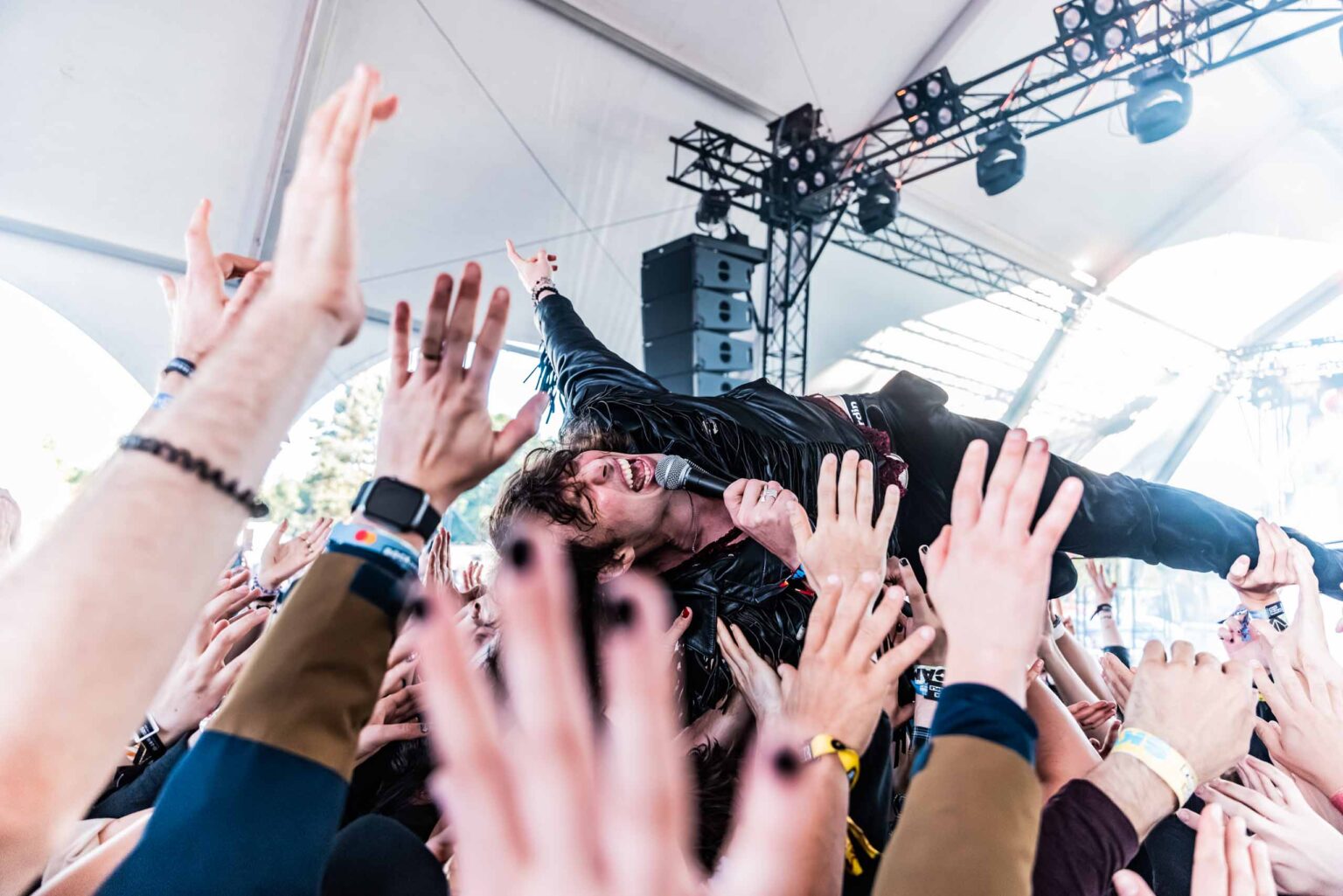 Barns Courtney crowd-surfing over a forest of raised hands at a live show